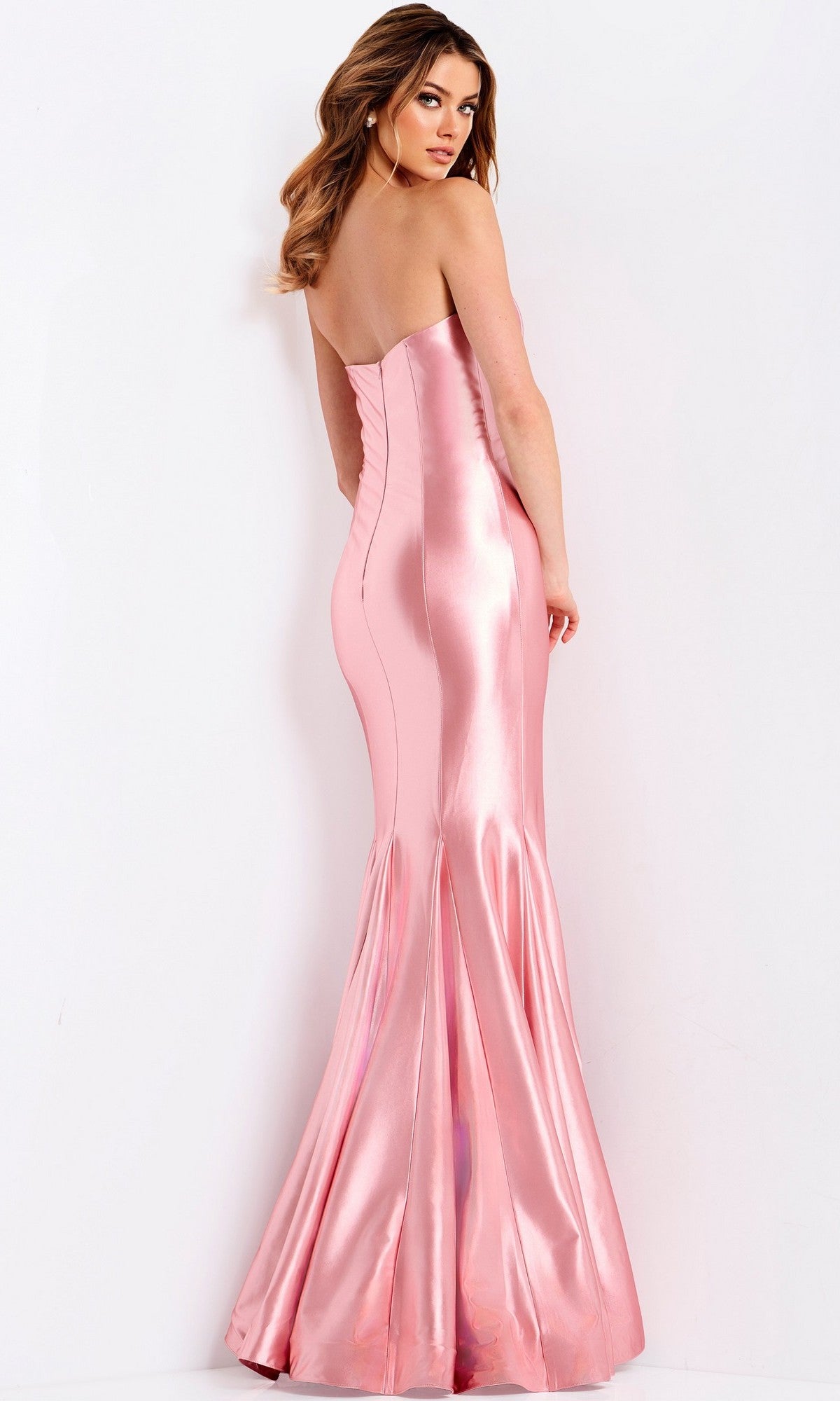A woman models the Jovani 48744 long prom dress—a shiny pink, strapless satin mermaid gown—facing away and looking over her shoulder against a plain white background.